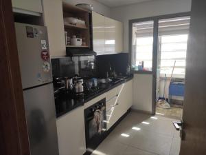 a kitchen with a stove and a refrigerator at Mansbay Beach Dalia in Mohammedia
