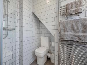 ein weißes Badezimmer mit Toilette und Treppe in der Unterkunft Coastal Cottage in Norwich + 7 Fotos