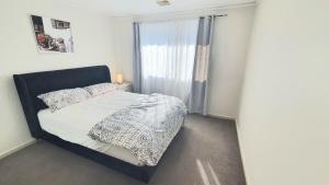 a small bedroom with a bed and a window at Timeless Tranquility in Belconnen