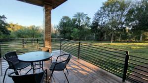 eine Terrasse mit Tisch und Stühlen und einem Zaun in der Unterkunft Casa Las Aves in Obligado