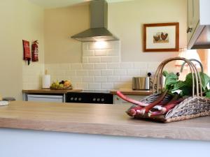 une cuisine avec un comptoir avec un panier de légumes dans l'établissement Club Cottage, à Dummer