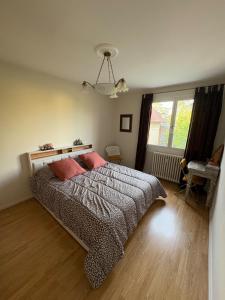 a bedroom with a bed and a window at Entre Lac, Fleurs et Montagnes in Thonon-les-Bains