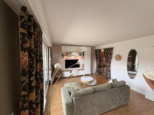 a living room with a couch and a tv at Entre Lac, Fleurs et Montagnes in Thonon-les-Bains