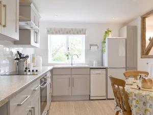 a kitchen with white cabinets and a white refrigerator at Cherry Cottage - Ukc3990 in South Perrott