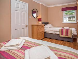 a bedroom with two beds and a mirror at Gatekeepers Cottage Uk6728 in Lydstep +6 photos