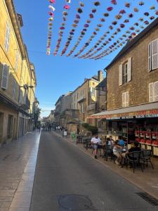 an empty city street with people sitting at tables at STUDIO ECUYER centre historique in Sarlat-la-Canéda +2 photos