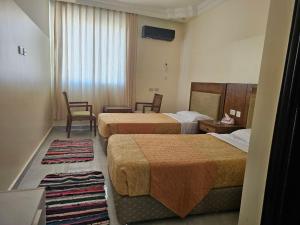 a hotel room with two beds and a table and chairs at Petra Summit Hotel in Petra