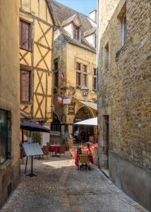 an alley in an old building with tables and chairs at STUDIO ECUYER centre historique in Sarlat-la-Canéda