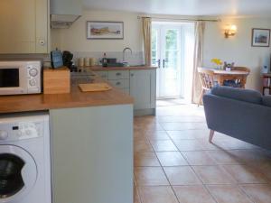 a kitchen and living room with a washer and dryer at Wren Cottage in Netherbury