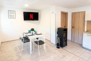 a dining room with a table and chairs and a stove at Ady Wellness Apartmanház - Privát jacuzzi & infraszauna in Orfű