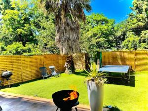 a backyard with a grill and a table and a fence at Maison Frappaz in Villeurbanne