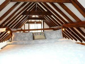 ein Schlafzimmer mit einem großen Bett im Dachgeschoss in der Unterkunft Stable Cottage in Icklesham + 8 Fotos