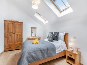 a bedroom with a bed and a wooden cabinet at Old Highwood - Piggy In The Middle in Luppitt +15 photos