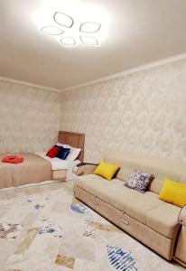 a room with two beds and a couch and a bed at Квартира после ремонта in Taraz