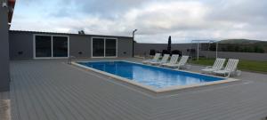 a swimming pool with lounge chairs next to a house at 3BL Retreat - Escape & Poolparty in Praia da Vitória