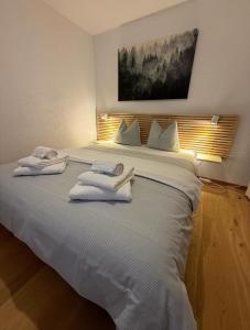 Un dormitorio con una gran cama blanca con toallas. en Rothornblick 32 by Arosa Holiday, en Arosa 8 fotos más