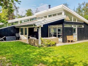 a house with a large deck with a lawn at 8 person holiday home in Græsted-By Traum in Udsholt Sand