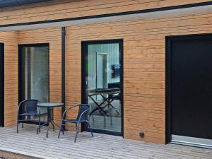 Sjølundにある8 person holiday home in Sjølund-By Traumの椅子2脚とテーブル付きのデッキが備わる建物