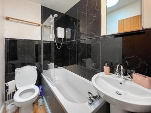 une salle de bain avec des toilettes blanches et un lavabo dans l'établissement Ty Capel Cottage, à Betws-y-coed