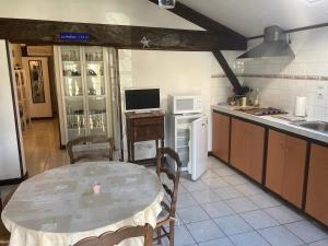 a kitchen with a table and a kitchen with a microwave at La Landaise avec jardin de 1 à 4 personnes in Lit-et-Mixe
