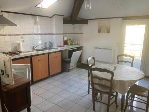 a kitchen with a table and chairs in a kitchen at La Landaise avec jardin de 1 à 4 personnes in Lit-et-Mixe