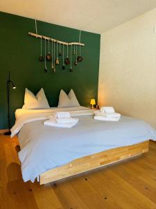 1 cama blanca grande en una habitación con una pared verde en Rothornblick 32 by Arosa Holiday, en Arosa