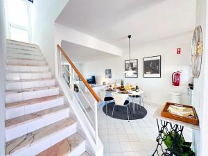 un appartamento bianco con sala da pranzo e scale di Stunning Sunrise & Sunset Rooftop Condo by BeCherish ad Albufeira