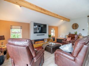 a living room with leather furniture and a fireplace at Briar Cottage in Great Eccleston
