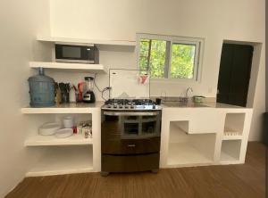 a small kitchen with a stove and a counter at Villa Los Delfines 2 in Monterrico