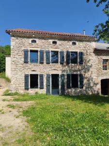 an old stone building with windows in a field at Le Clos d'Aboulin in Saint-Christophe-dʼAllier