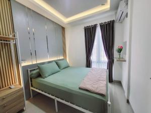 a small bedroom with a bed and a window at Michelia Homestay Singkawang in Singkawang