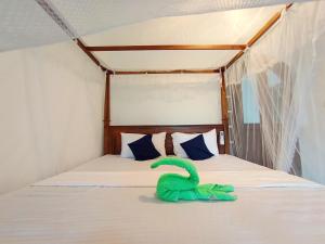 a bedroom with a bed with a green object on it at Bimsara Mount Villa in Weligama