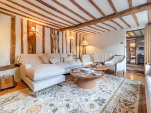 a living room with a white couch and a table at All Saints Cottage in Saffron Walden