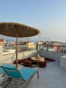 a patio with a chair and an umbrella and a table at imssouane sea surf in Imsouane