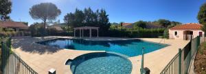 a swimming pool in a yard with a fence at Maison de vacances, jacuzzi privé, piscine in Forcalqueiret