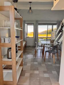 Una cocina y un comedor con mesa y sillas. en Sabai Casas de Playa, en La Paloma