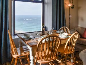 a dining room table with chairs and a large window at Bishop Rock - Grl in Trevilley