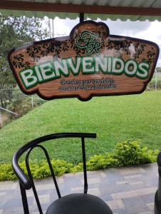 Un cartel de una barbería con una silla delante. en Parcela el privilegio, en Totoró