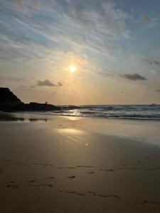 una puesta de sol en una playa con el océano en L20 at Seven Bays Park, en St Merryn 3 fotos más