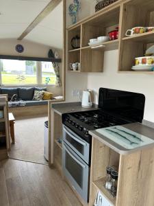 cocina con fogones en una habitación en L20 at Seven Bays Park, en St Merryn