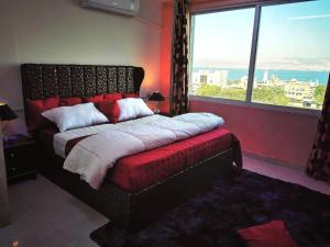 a bedroom with a large bed and a large window at Blue Cs in Aqaba