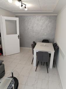 une salle à manger avec une table et des chaises blanches dans l'établissement Stan, à Negotin