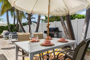 une table blanche avec des chaises et un parasol dans l'établissement Casa Blanca Lighthouse Point with 4 BR with Pool, à Lighthouse Point