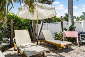 - 2 chaises et un parasol sur la terrasse dans l'établissement Casa Blanca Lighthouse Point with 4 BR with Pool, à Lighthouse Point