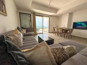 una sala de estar con un sofá y una mesa en Spacious Duplex Sea & Waves, en Tamraght Ouzdar