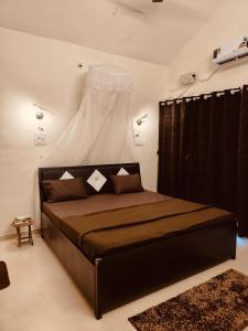 a bedroom with a bed with a dress hanging above it at Hillview Escape - Cozy 1bhk apartment in Karjat