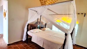 un lit à baldaquin dans une chambre dans l'établissement Beachfront Villa, Bofa Rd Kilifi, à Kilifi 29 autres photos