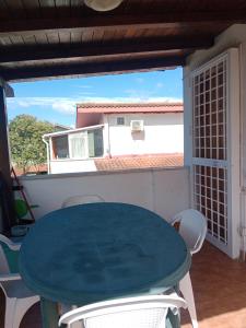 a table and chairs on a balcony with a view of a house at Casa vacanza Roby in Lido dei Pini +5 photos
