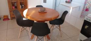 una mesa de madera con 4 sillas en la cocina en Quarto Rustico em Alfenas, en Alfenas 1 foto más