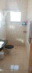 Un baño con ducha, inodoro y lavabo. en Quarto Rustico em Alfenas, en Alfenas